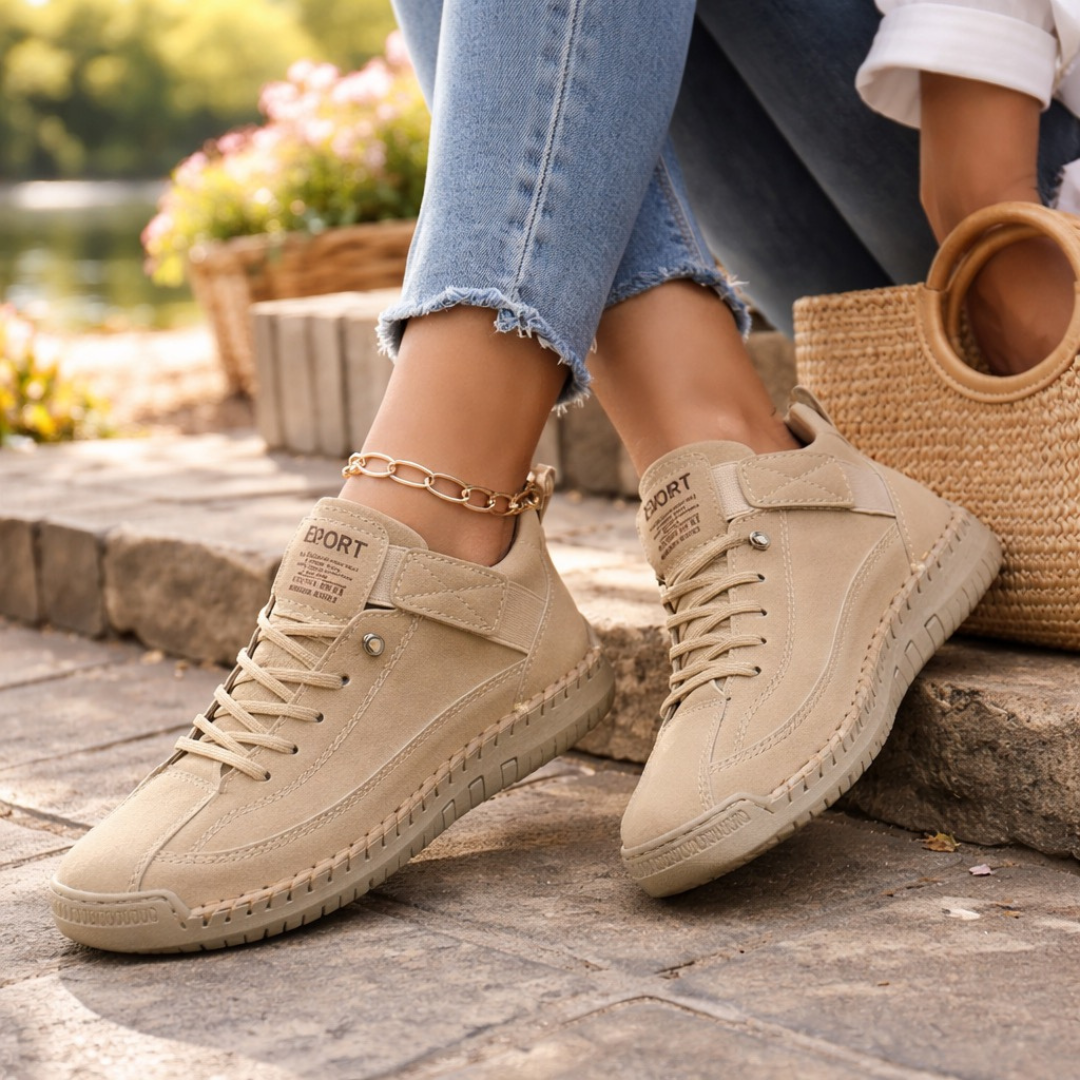 Beige comfort sneakers with lace-up front, padded collar, and chain ankle strap