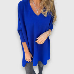 Blue oversized V-neck sweater with loose knit and long sleeves.