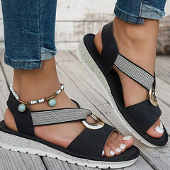 Black flat sandals with mesh strap and round gold-tone metal buckle