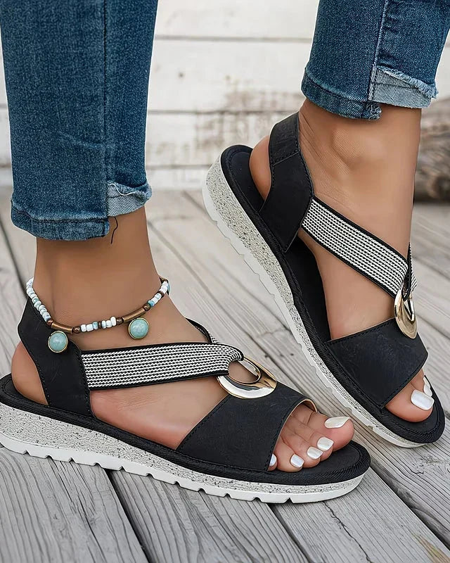 Black flat sandals with mesh strap and round gold-tone metal buckle