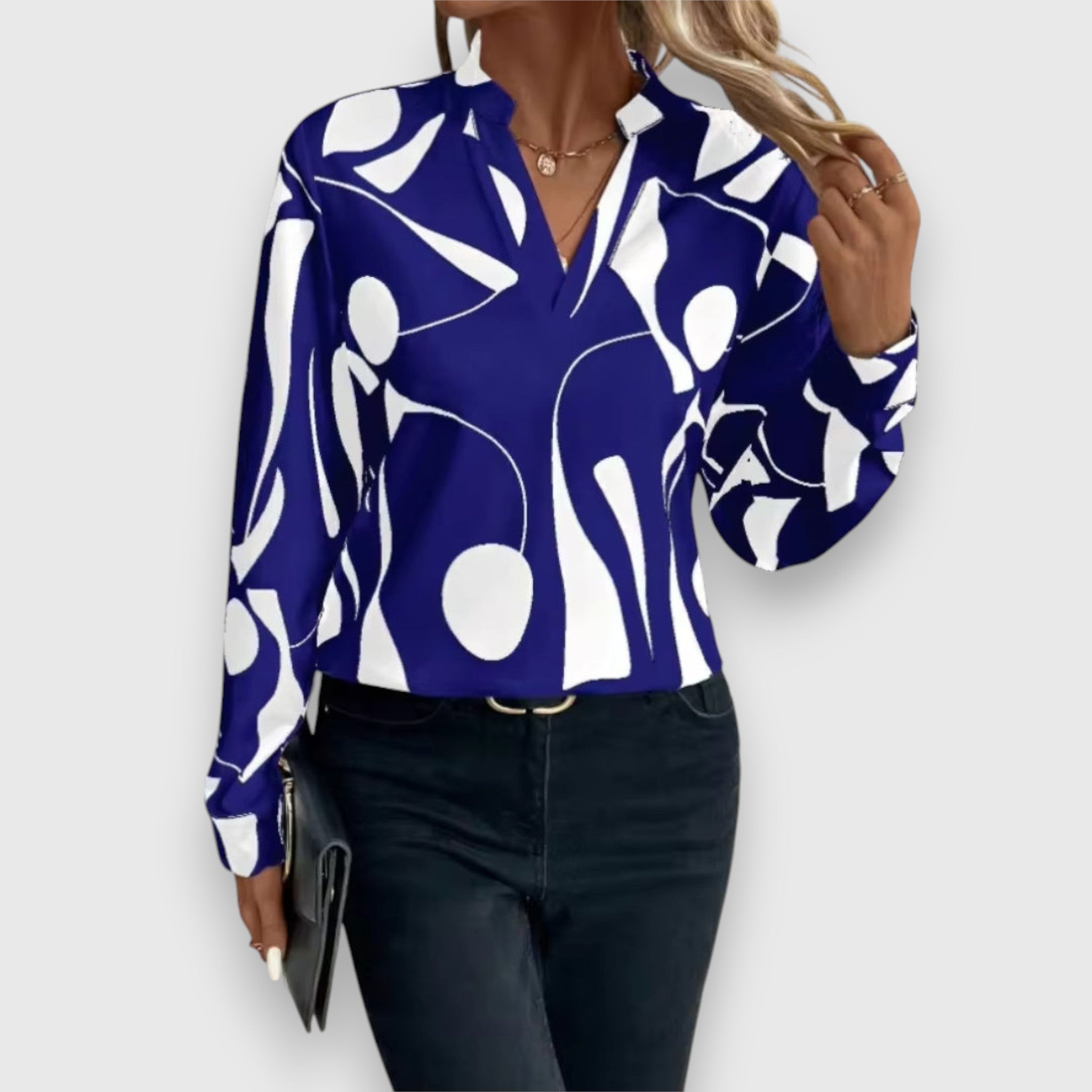Blue long-sleeve V-neck blouse with bold white abstract pattern