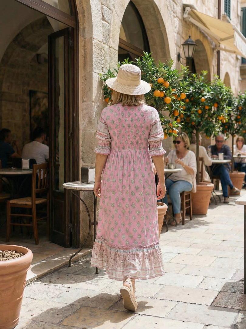 Pink V-neck tiered midi dress with short puff sleeves, patterned print, back view