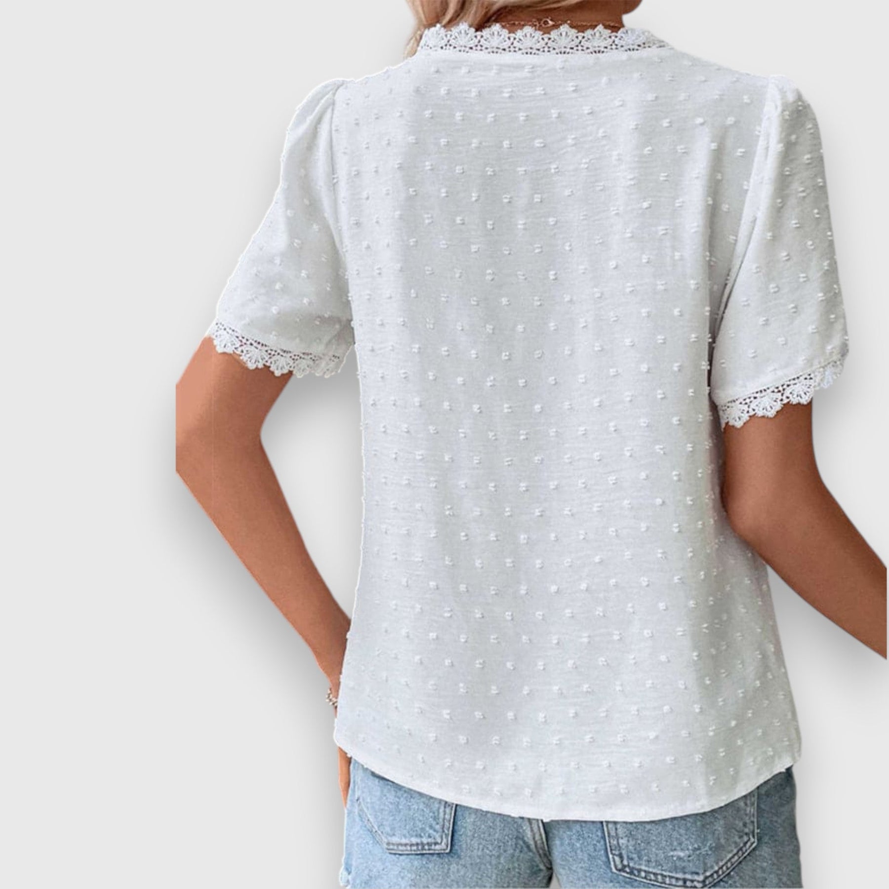 Wassa white short-sleeve button-up shirt from back view with lace hem and dot texture