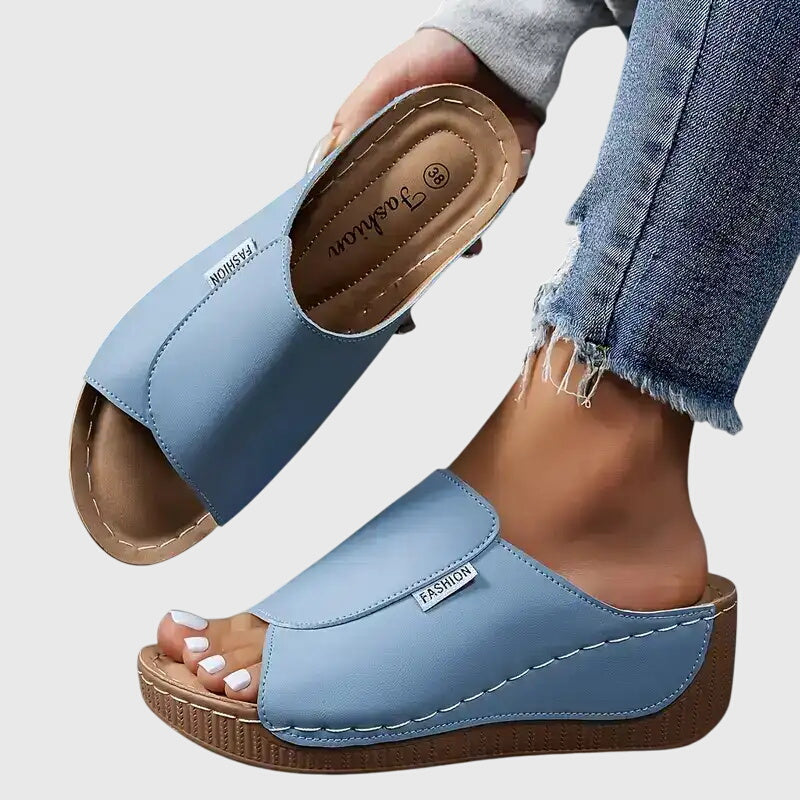 Light blue wedge sandals with wide strap and open toe, stitched trim and textured sole