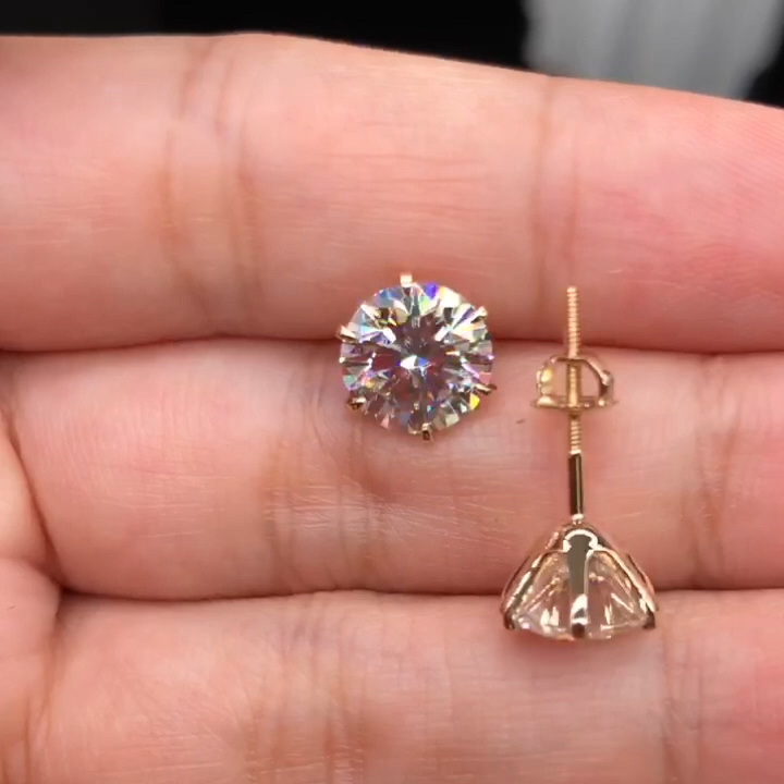 Gold-tone crystal stud earrings with round stones and small dangling charm detail