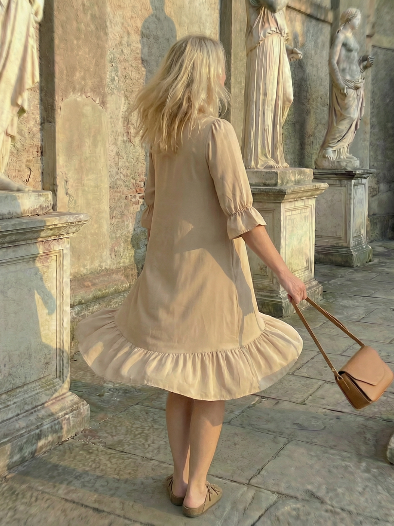 Beige ruffle day dress back view with tiered hem and elbow puff sleeves