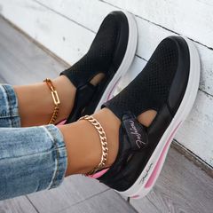 Black perforated comfort sneakers with side cutout, elastic strap, and white sole