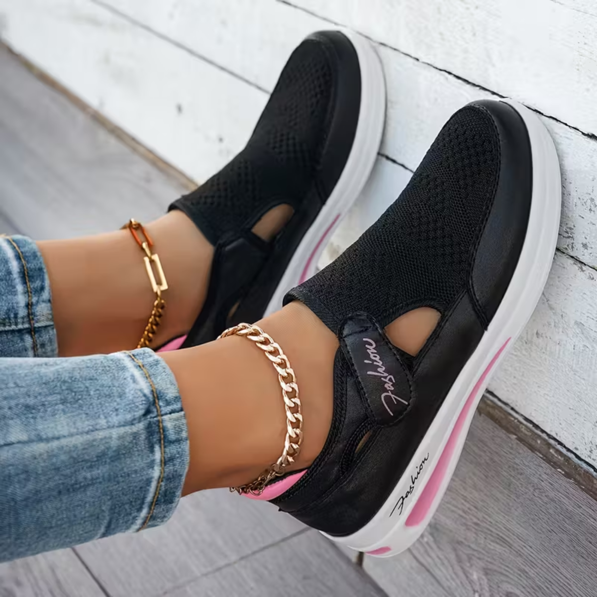 Black perforated comfort sneakers with side cutout, elastic strap, and white sole