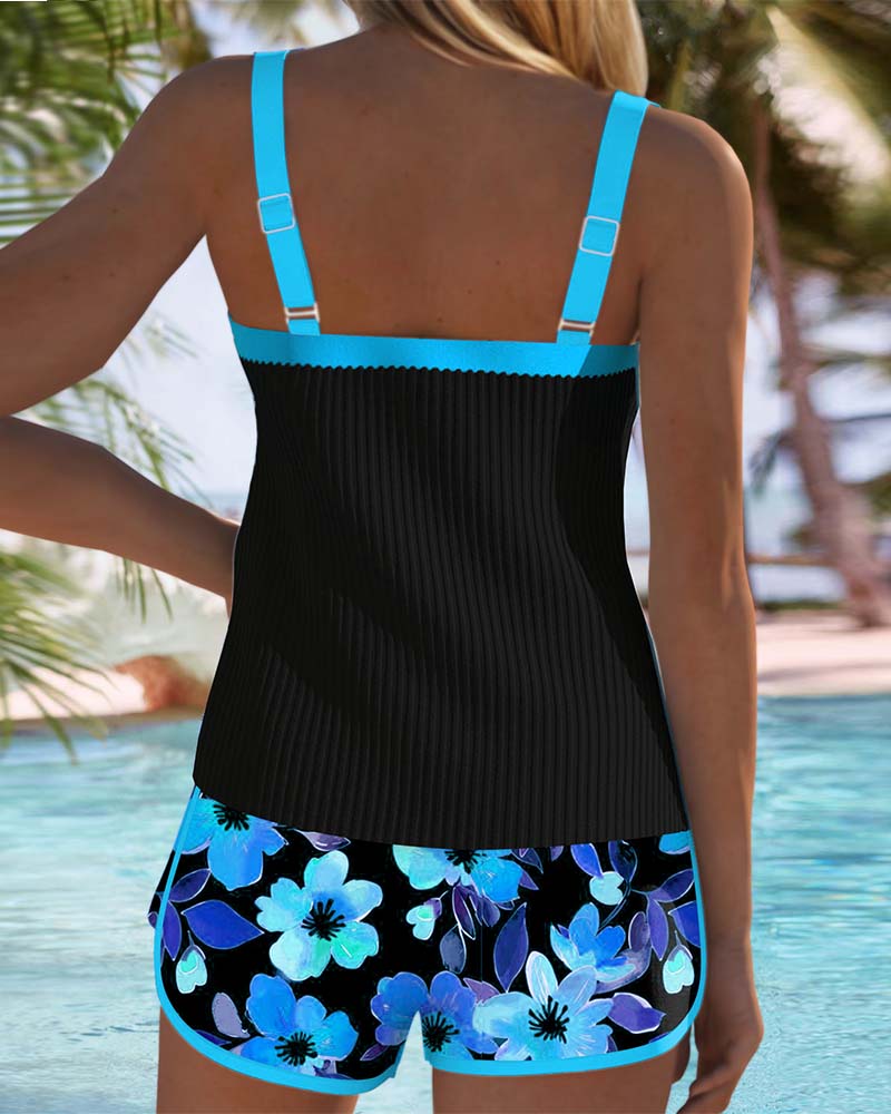 Back view: black tankini top with turquoise straps and blue floral swim shorts.