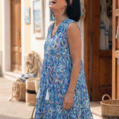 Blue sleeveless printed midi dress with V-neck, tassel accents, and flowing tiered hem