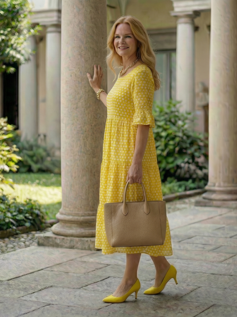 Yellow polka dot tiered midi dress in full view with short sleeves and tiered skirt