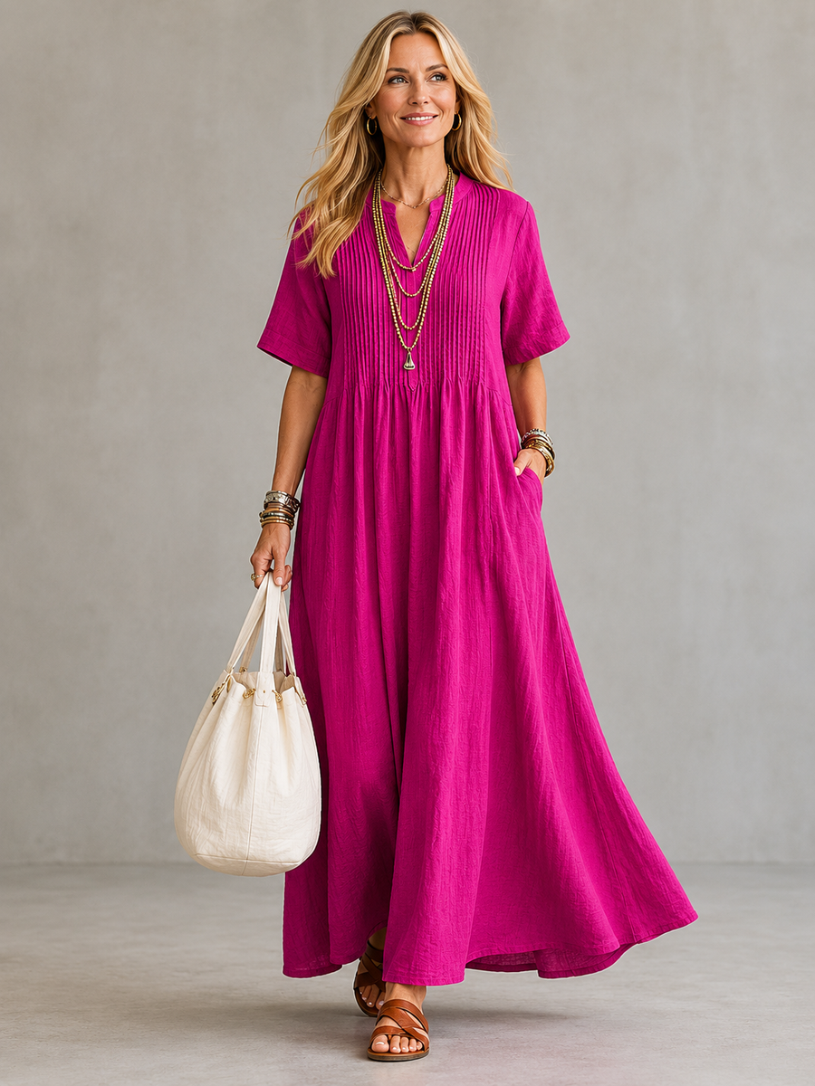 Pink pleated maxi dress with V-neck and short sleeves, gathered waist.