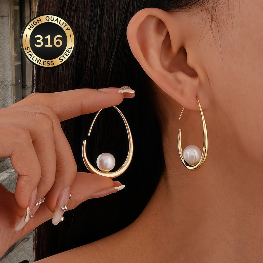 Gold crescent hoop earrings with white pearl, curved teardrop shape on ear.
