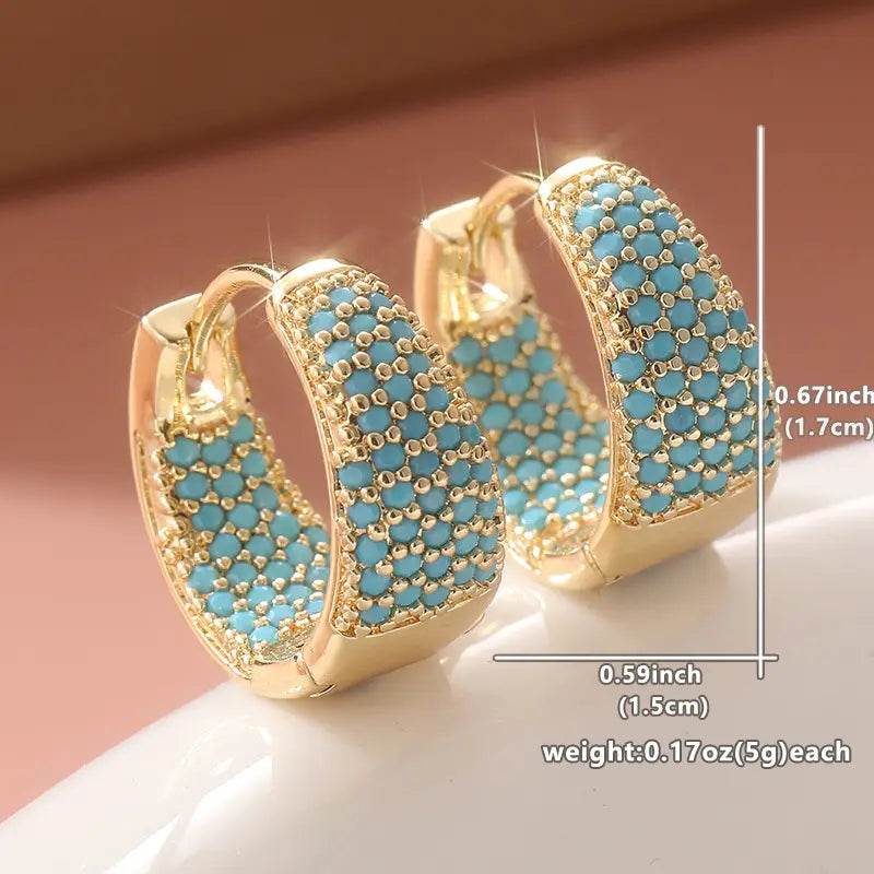 Gold-tone hoop earrings with turquoise beadwork lattice detail, close-up view