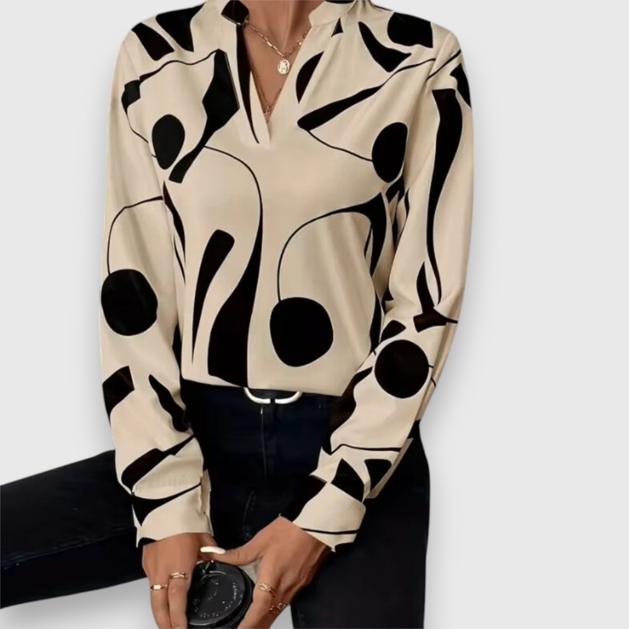 Beige long-sleeve V-neck blouse with bold black abstract pattern