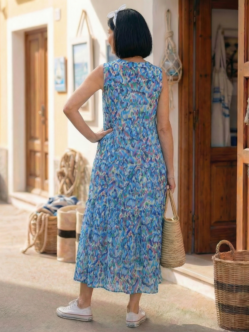 Back view of blue sleeveless printed midi dress with tiered skirt