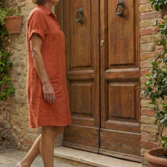 Orange linen-look courtyard walk dress in side profile with short sleeves and button front