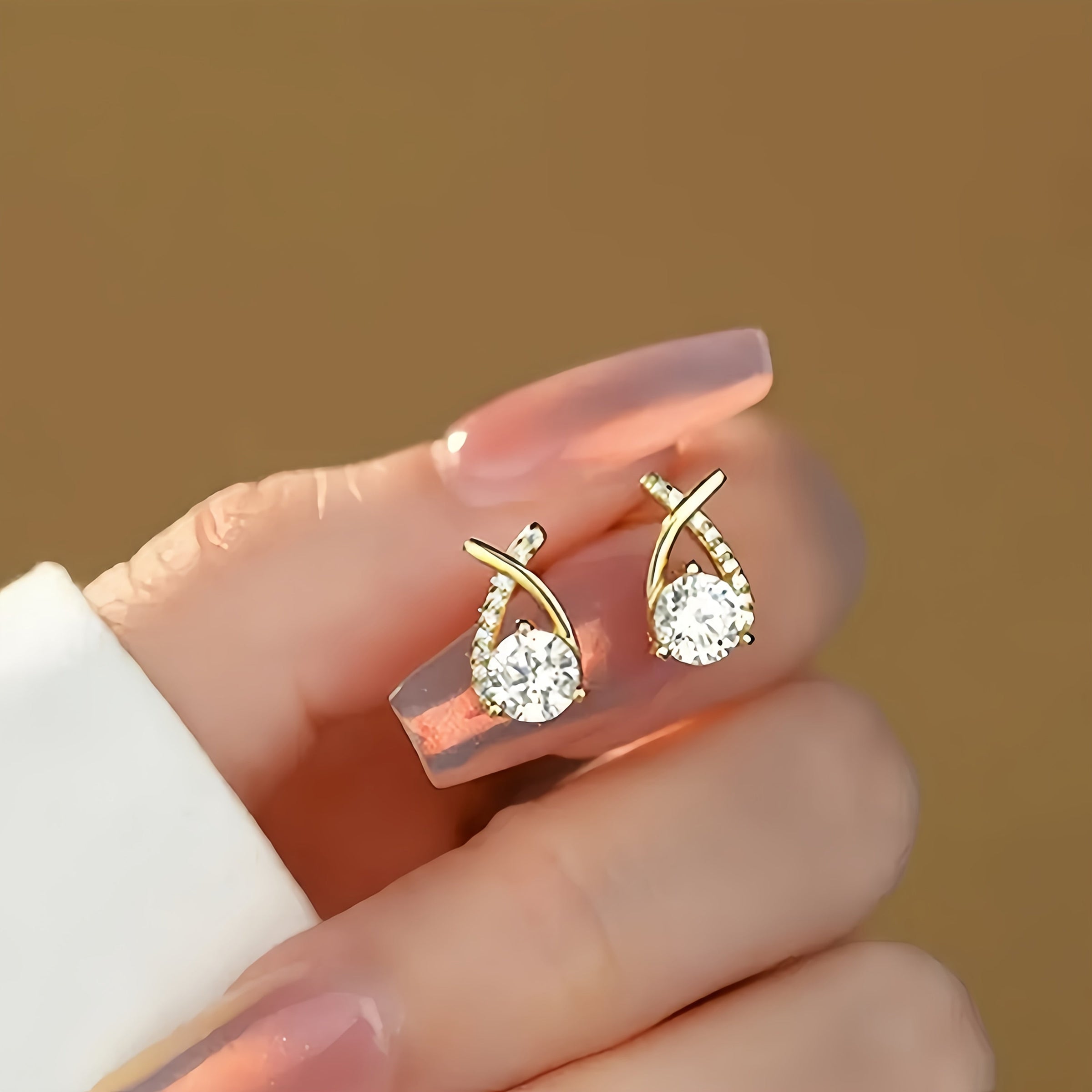 Gold-tone stud earrings close-up with round crystal drops and gold hoop backs