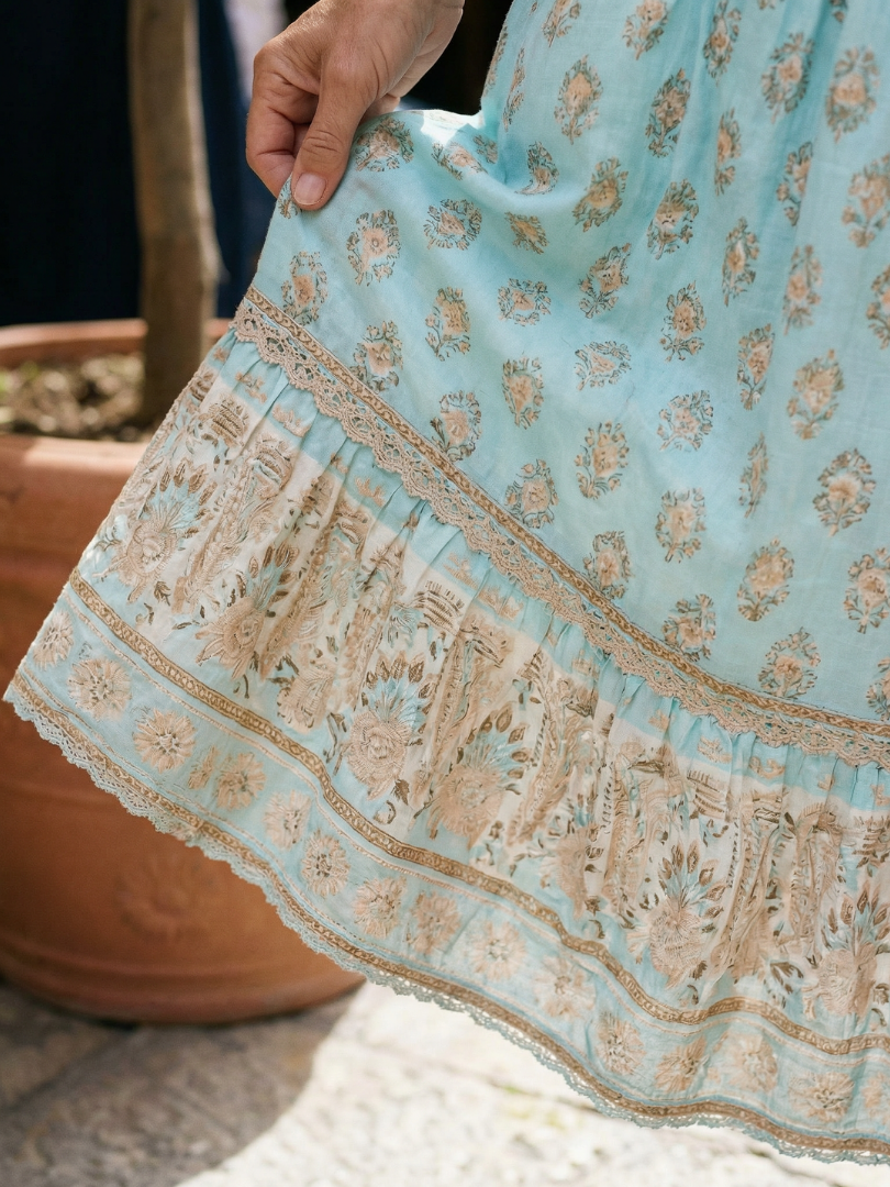 Sky blue tiered midi dress hem with lace trim and floral embroidery pattern