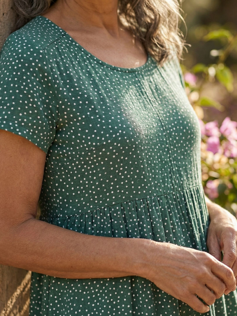 Green Meadow Drift dress close-up: dotted bodice with gathered waist and short sleeves