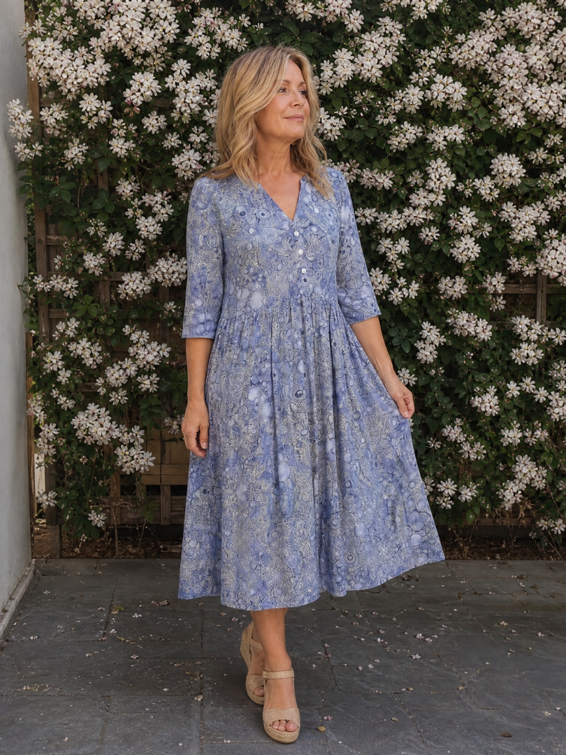Blue floral midi dress with V-neck, button front, and gathered midi skirt