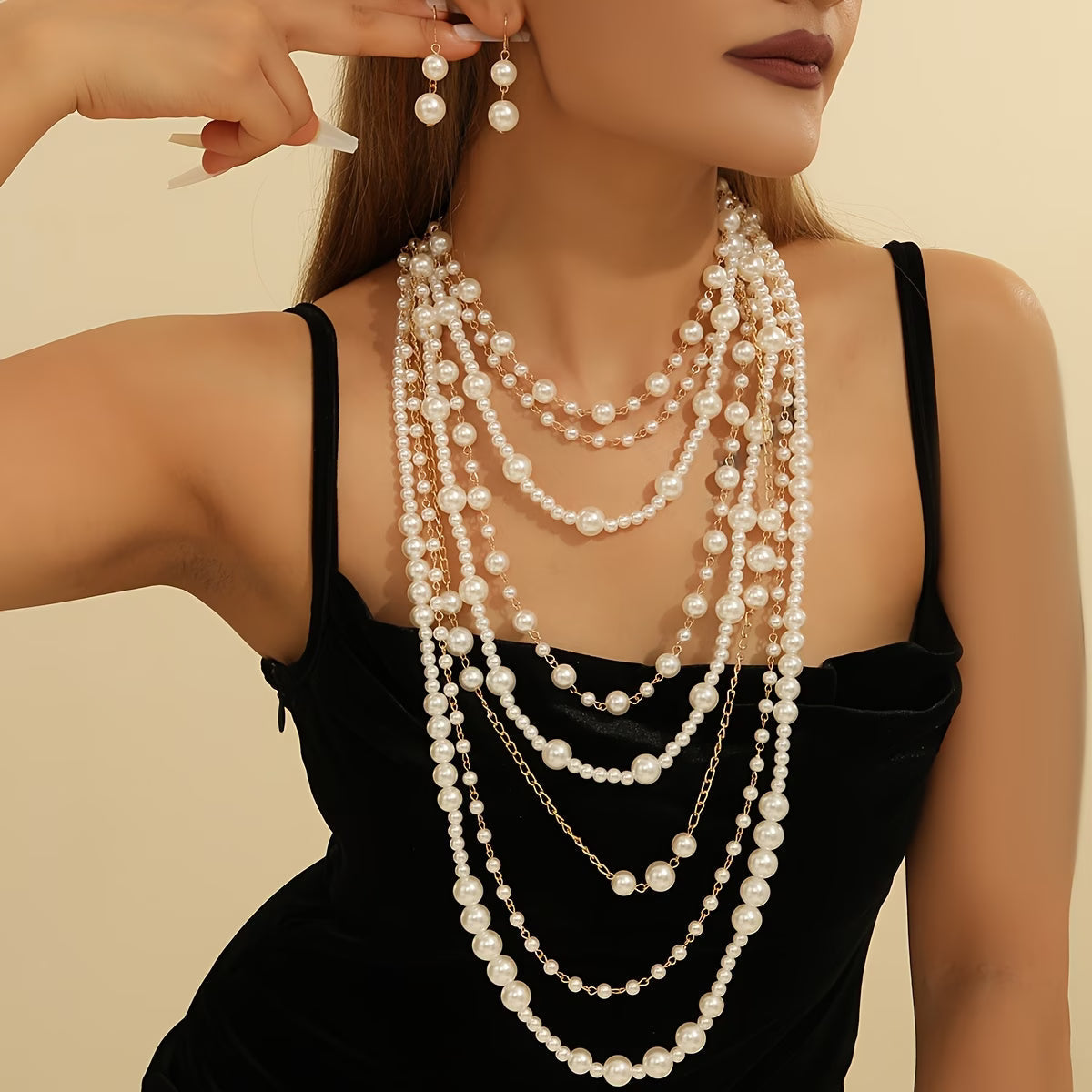 Multi-layer pearl statement necklace set with matching drop earrings on black top