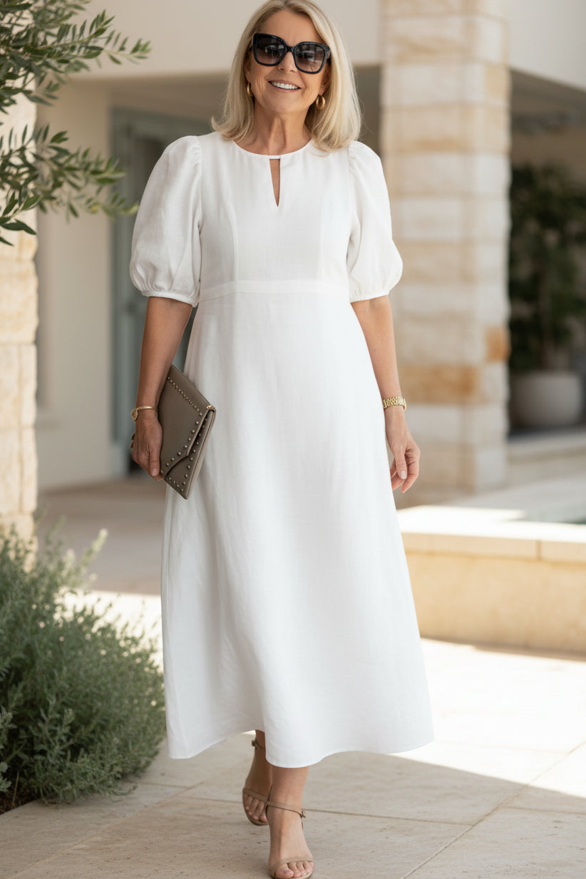 Soft white maxi dress with puff sleeves and keyhole neckline, gathered waist fit.