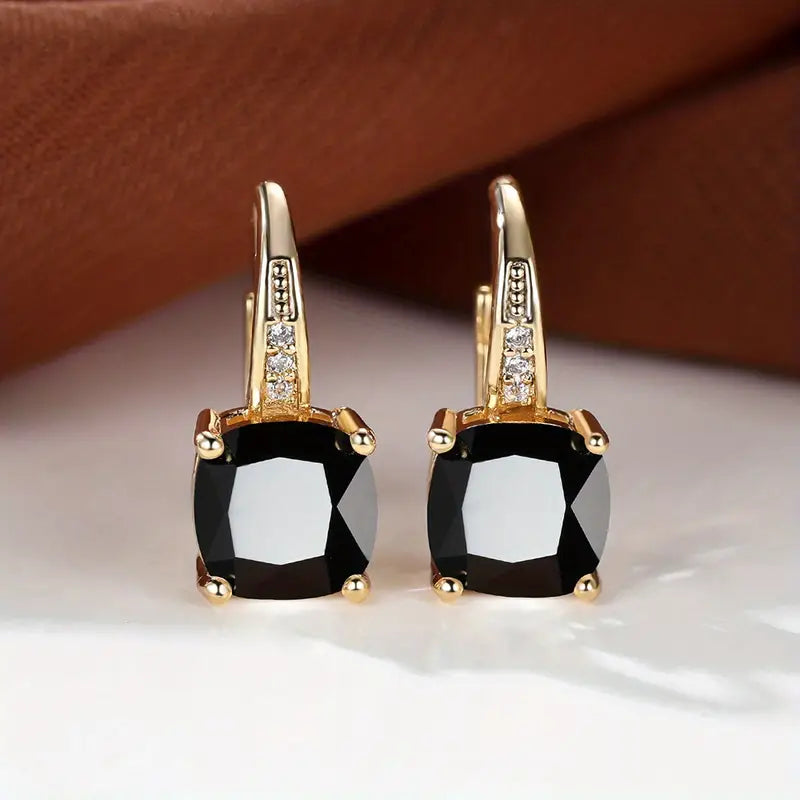 Gold hoop earrings with square black stones and small clear accents
