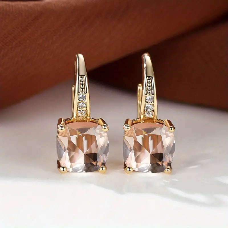 Gold hoop earrings with square pale pink stones and small clear accents