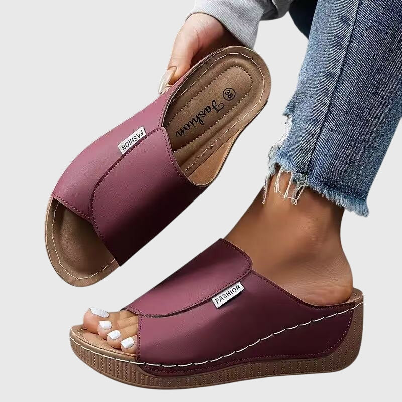 Purple wedge sandals with wide strap and open toe, stitched detail and textured sole