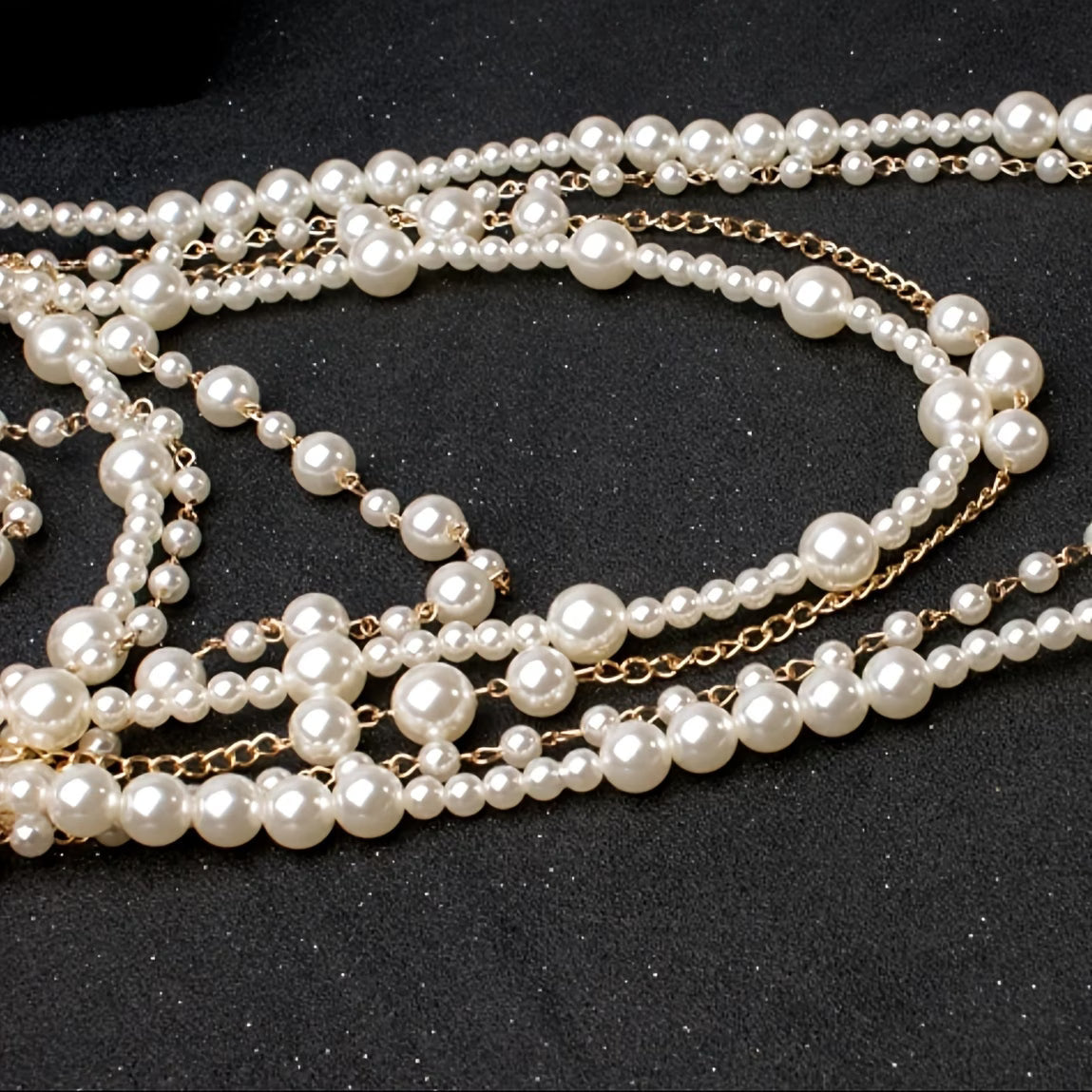 Close-up multi-strand pearl necklace with bead-by-bead texture and gold-tone accents