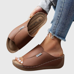 Brown wedge sandals with wide strap and open toe, stitched detail and textured sole