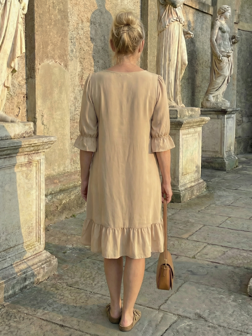 Beige ruffle day dress back view with tiered skirt and three-quarter puff sleeves