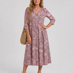 Pink floral midi dress with V-neck, three-quarter sleeves, and gathered skirt
