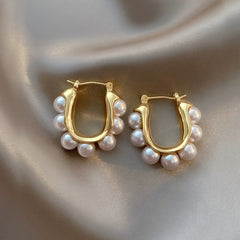 Pair of gold hoop earrings with white pearl cluster dangles