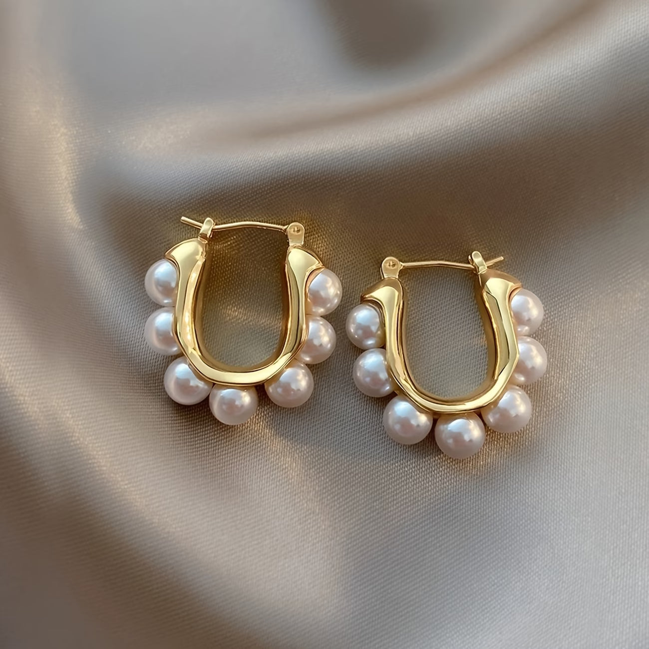 Pair of gold hoop earrings with white pearl cluster dangles