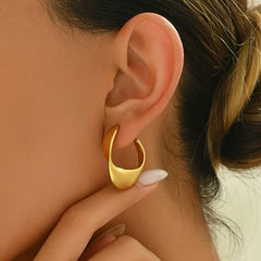 Gold twisted hoop earrings, curved geometric front, side view on ear