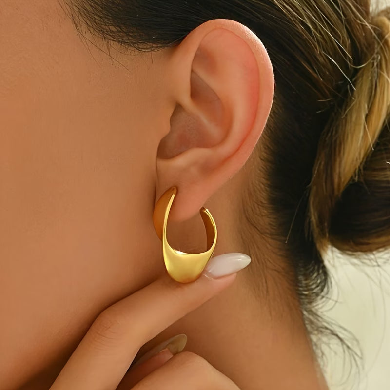Gold twisted hoop earrings, curved geometric front, side view on ear
