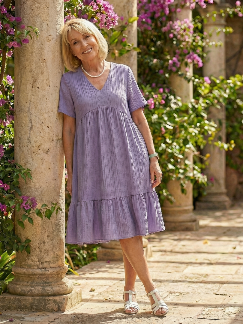 Purple woven ease dress with V-neck, short sleeves, and tiered skirt