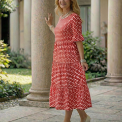 Red polka dot tiered midi dress in side view with short sleeves and tiered skirt