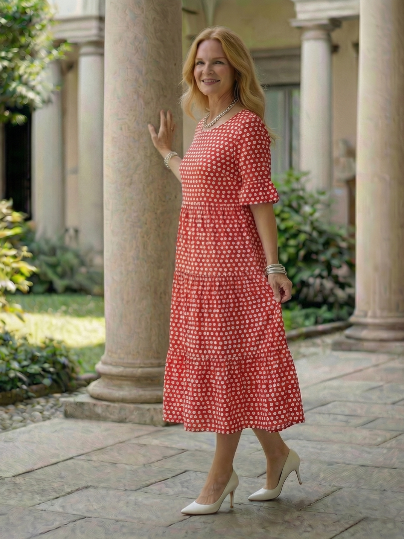 Red polka dot tiered midi dress in side view with short sleeves and tiered skirt