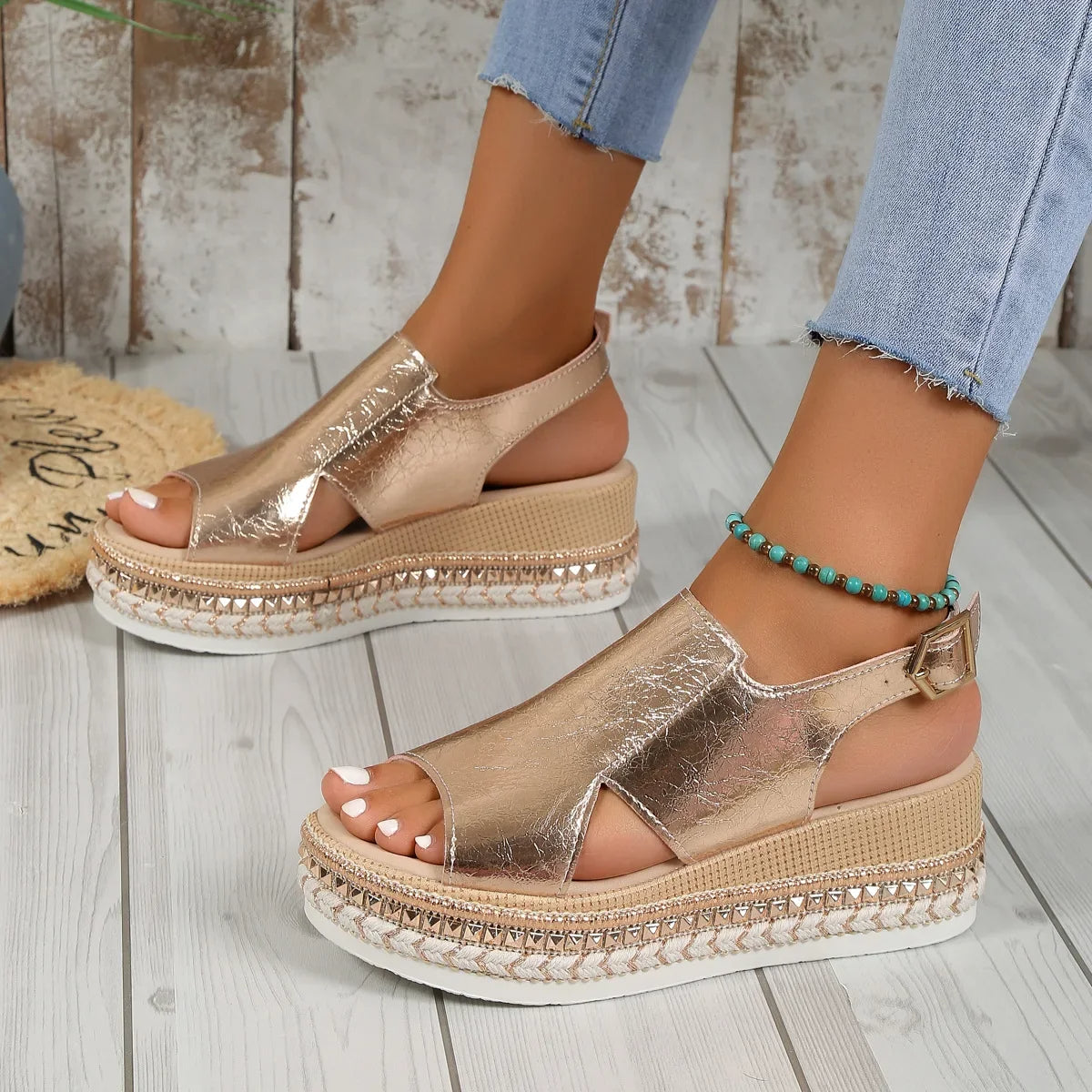 Silver metallic platform sandals with crisscross straps, ankle strap buckle, and woven trim