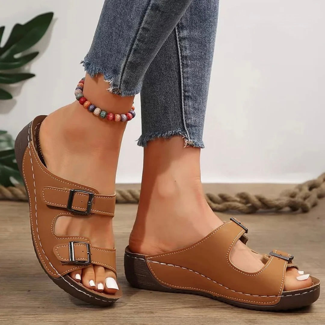 Brown open-toe wedge sandals with double buckles and stitched strap details