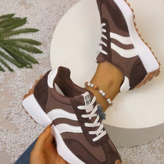 Brown comfort sneakers with white side stripes and lace-up front, chunky sole