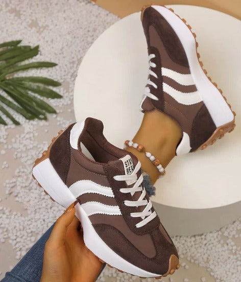 Brown comfort sneakers with white side stripes and lace-up front, chunky sole
