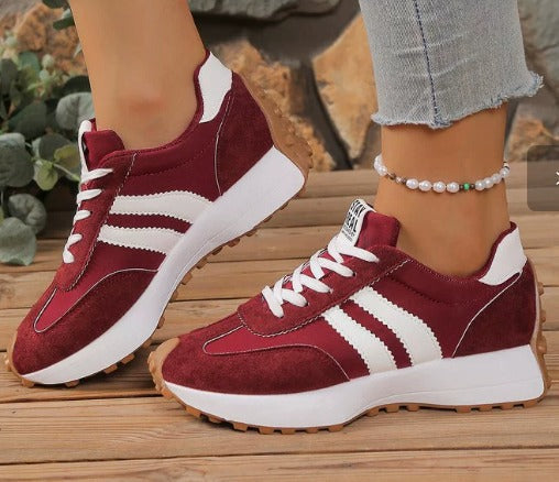 Burgundy comfort sneakers with white side stripes and lace-up front, chunky sole