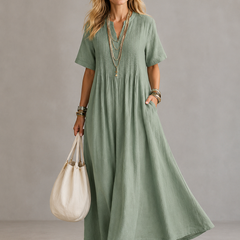 Green pleated maxi dress with V-neck and short sleeves, gathered waist.