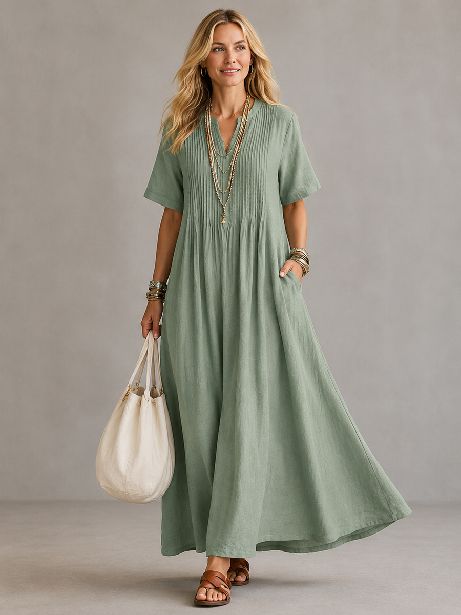 Green pleated maxi dress with V-neck and short sleeves, gathered waist.