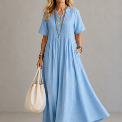 Blue pleated maxi dress with V-neck and short sleeves, gathered waist.