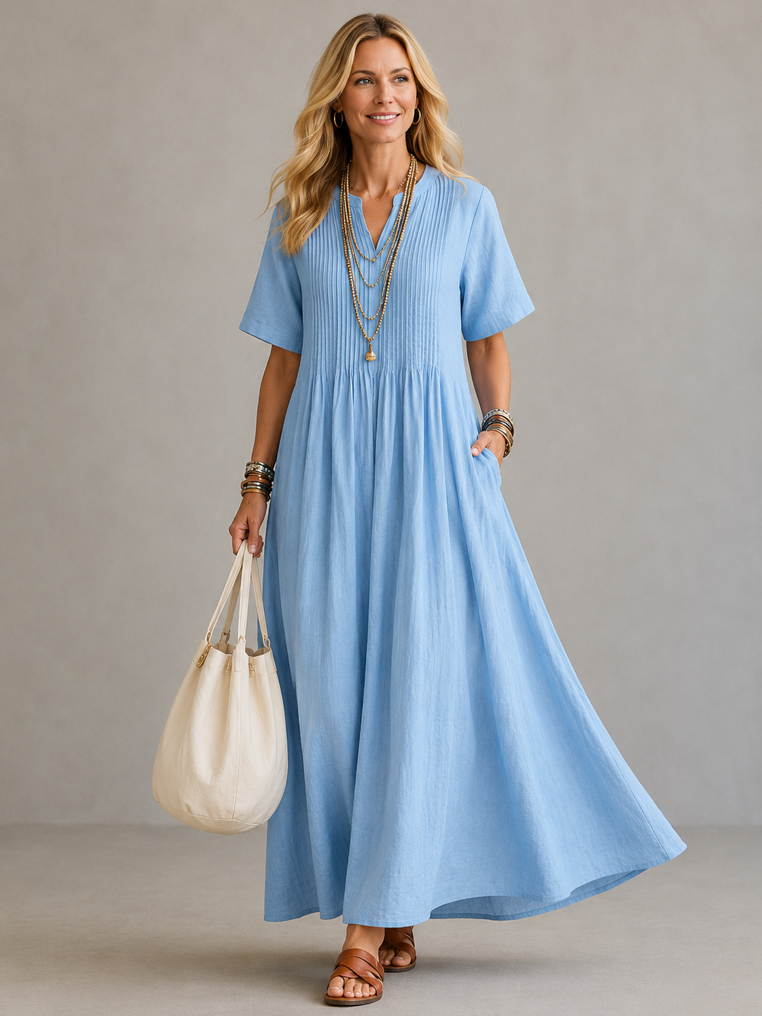 Blue pleated maxi dress with V-neck and short sleeves, gathered waist.